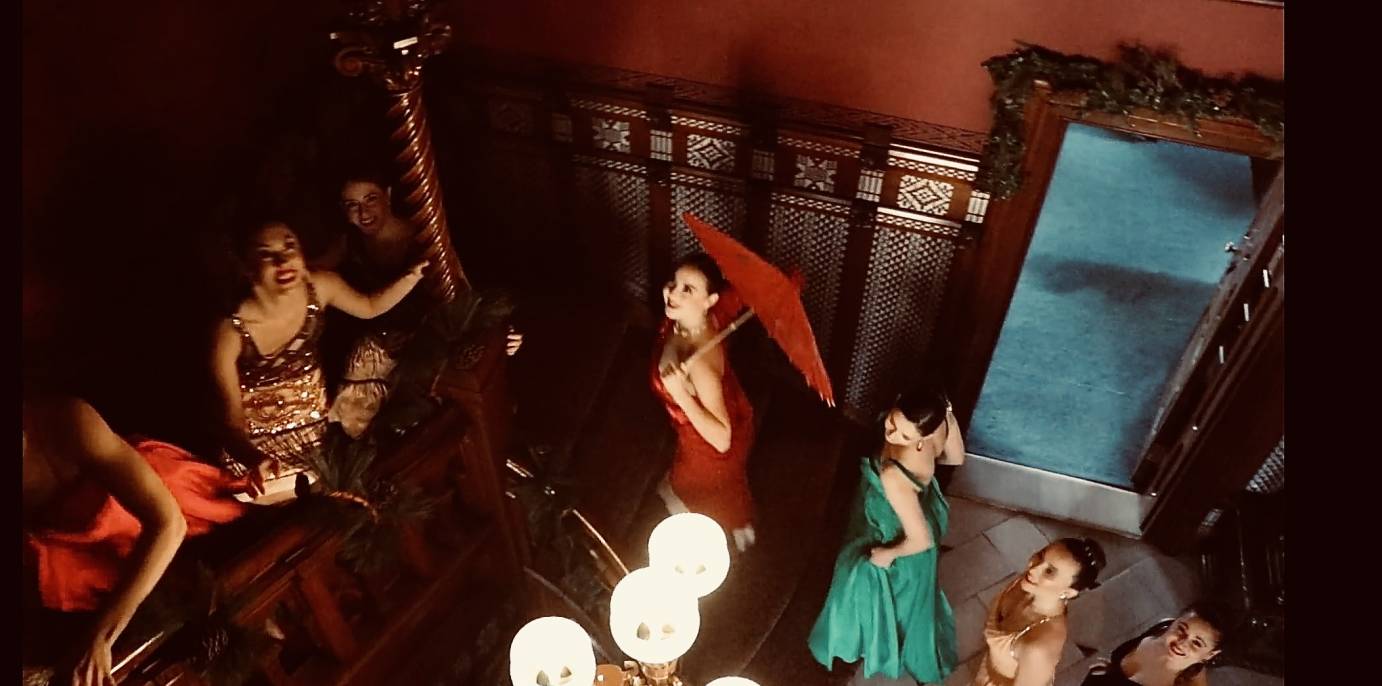 dancers in holiday dress climbing up the stairs of Mark Twain's house with expressions of wonder 