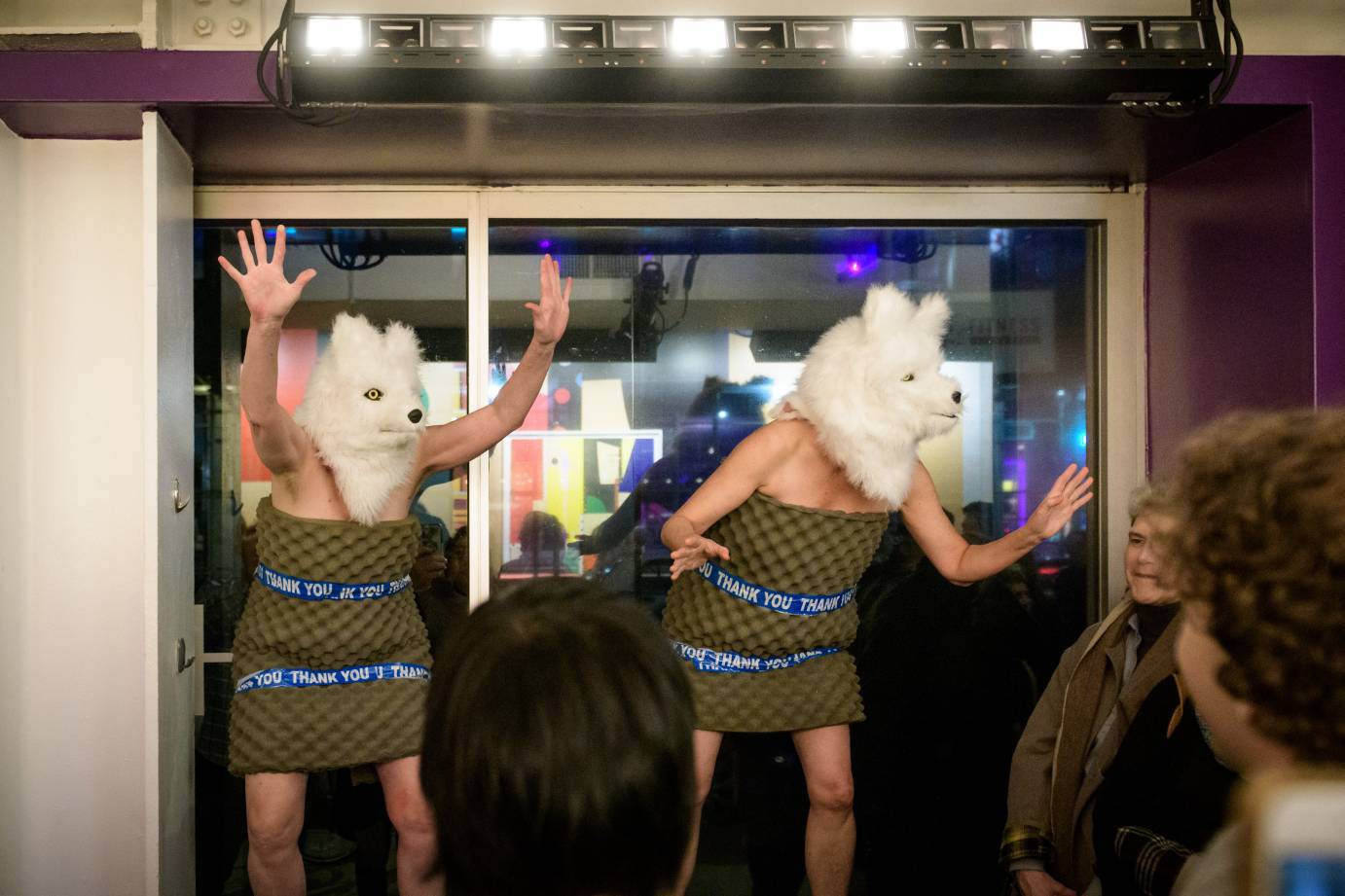 Two women in wolf heads get the crowd going in a theater lobby