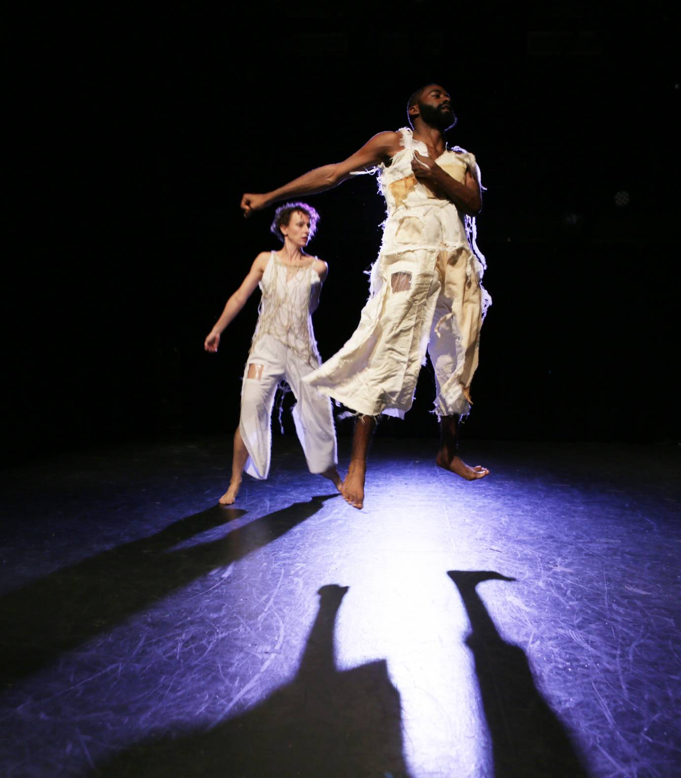 Two dancers jump with flexed feet