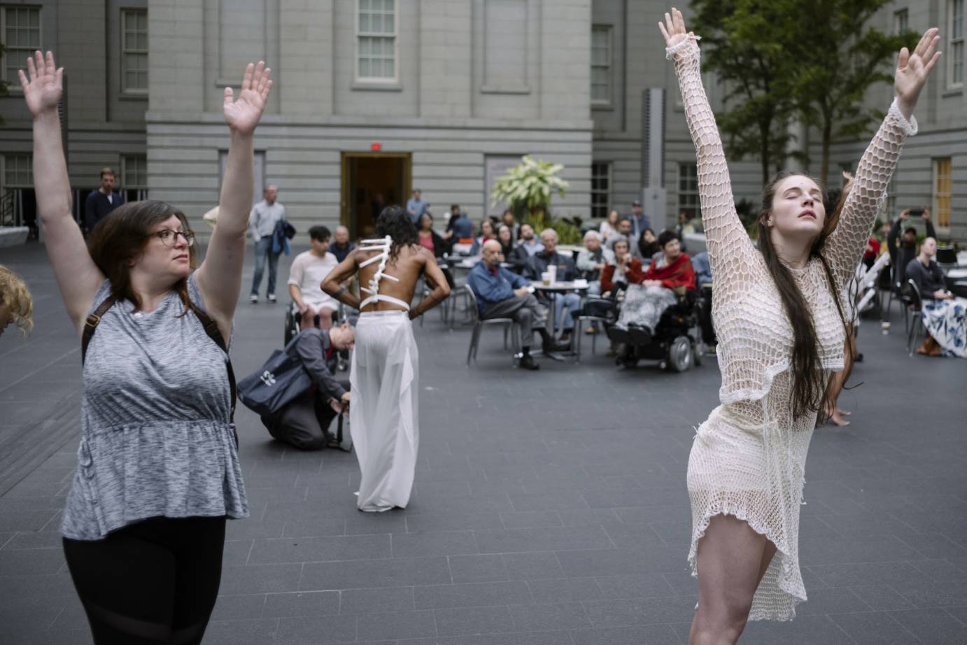 Pedestrians participate in ON DISPLAY with white-clad dancers