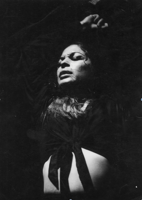 La Chana dances passionately with her arms above her head. The photo is in black and white and taken when La Chana was a young woman.