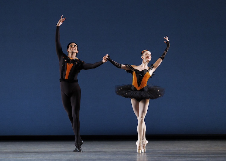 a couple hold hands as the present themselves to the audience with exuberance. The stand with legs crossed, he on raised toes, and she en pointe. The hands which are not held are raised above their heads in a semi-circle.