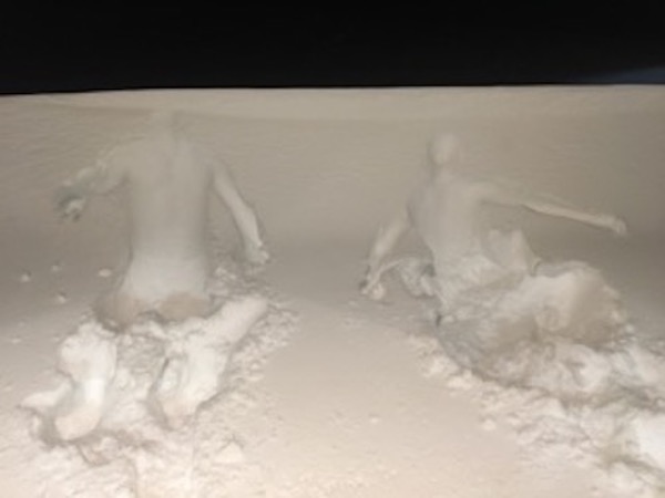 two dancers dive in deep snow emerging as ghostly white figures