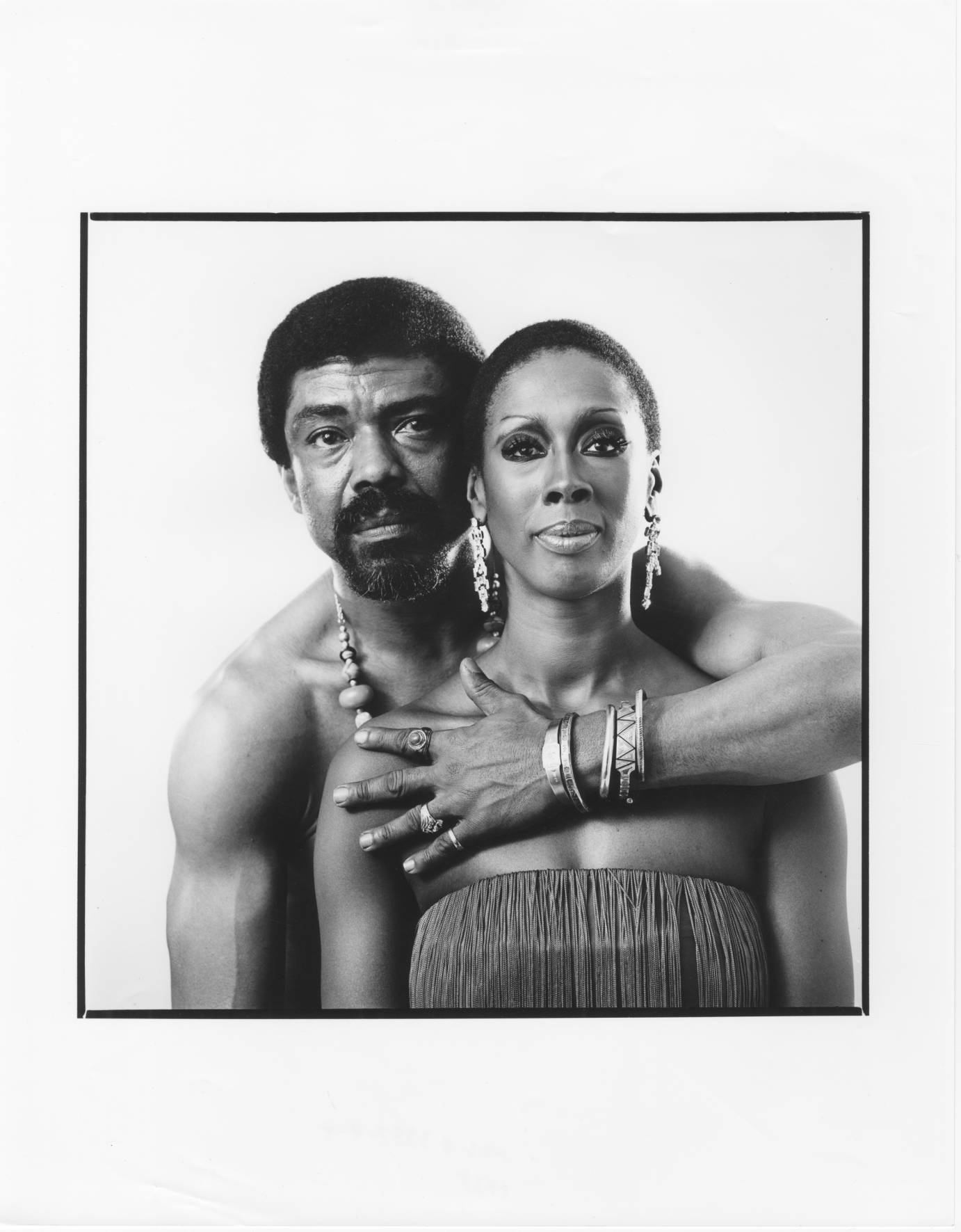 A bare-chested Alvin Ailey stands behind Judith Jamison with one arm around her