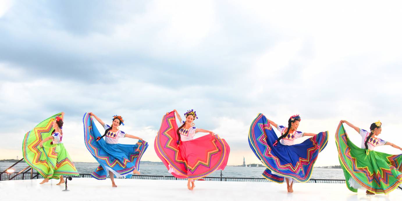 Five women hold colorful circle skirts with chevron trim in their hands.