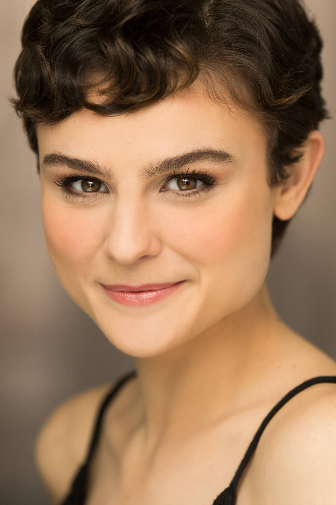A headshot of Melanie Moore features a woman with a brown pixie cut, brown eyes, and a pink-lipped smile.