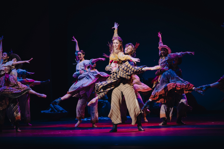 In colorful costumes representing Mexican culture a bevy of ballerinas are lifted high in front of their male partners. They float in airy arabesques and gaze directly at us.