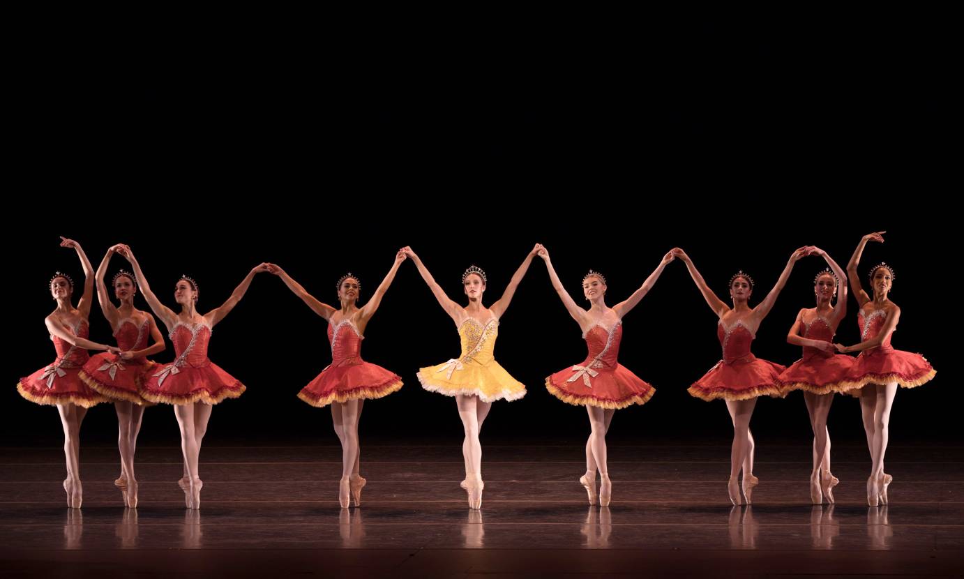 In a yellow tutu, Devon Teucher stands in the middle of a corps of women