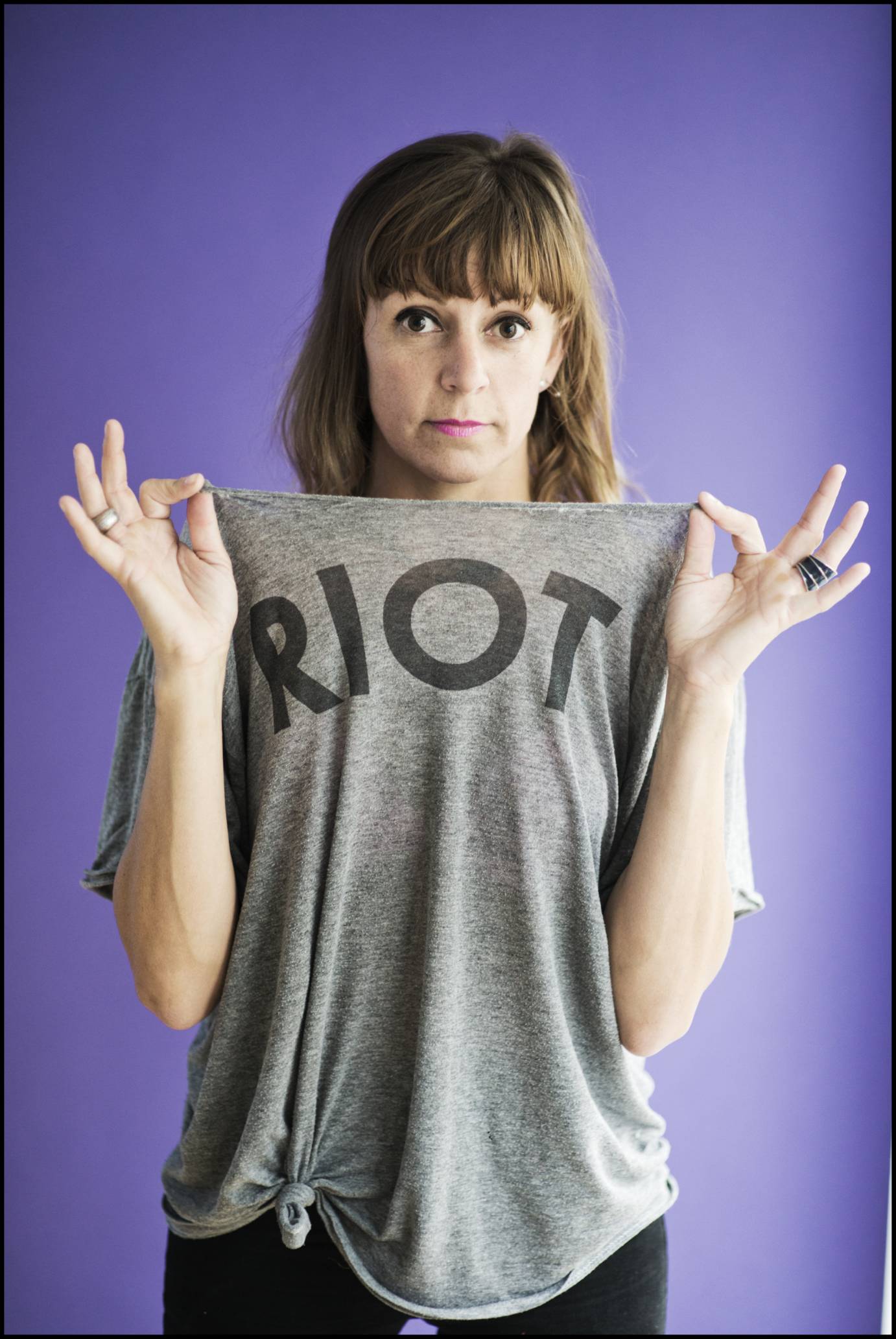 Adrienne Truscott wears a gray T-shirt that says RIOT
