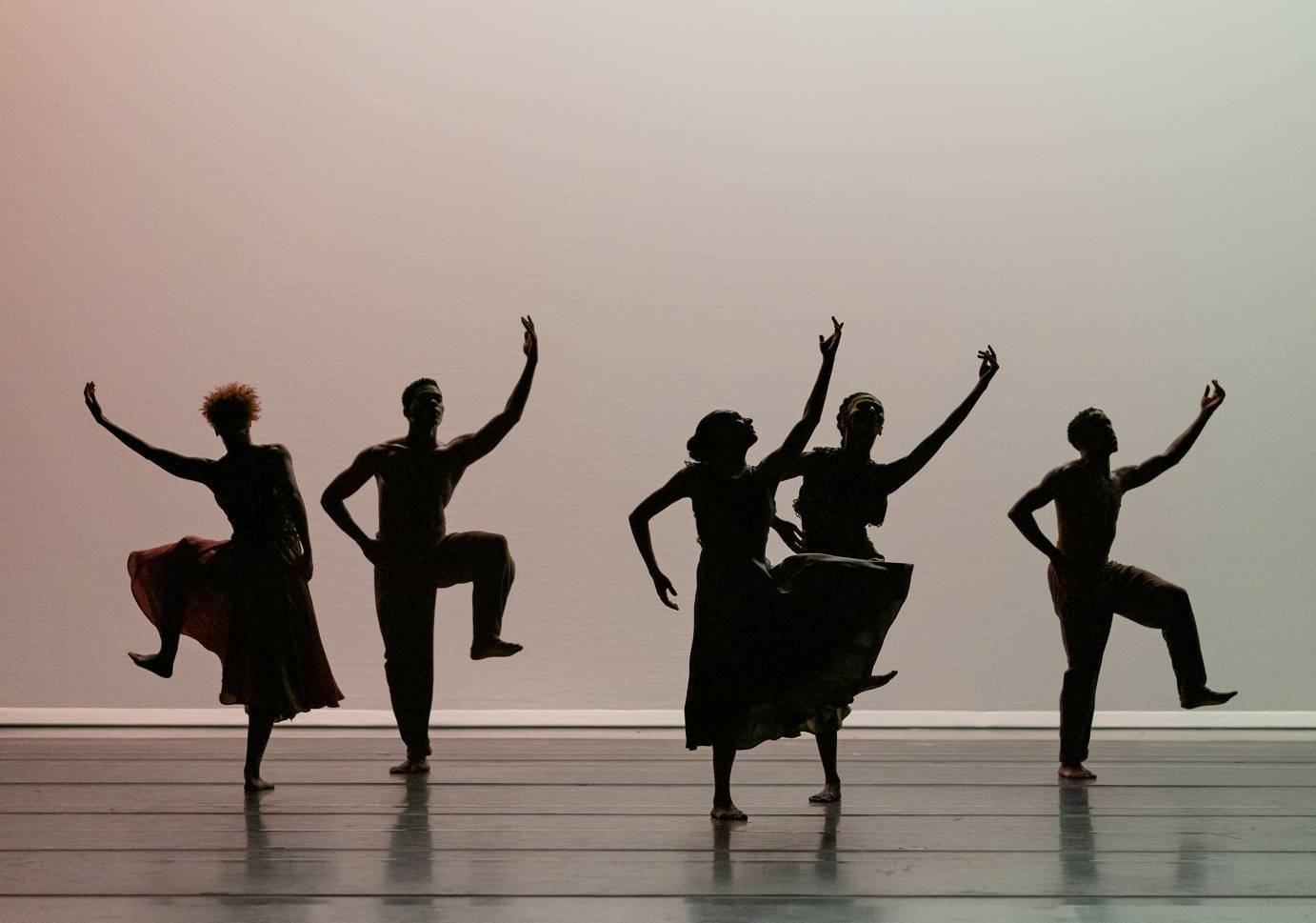 Dancers stomping with one arm lifted, the other on hips