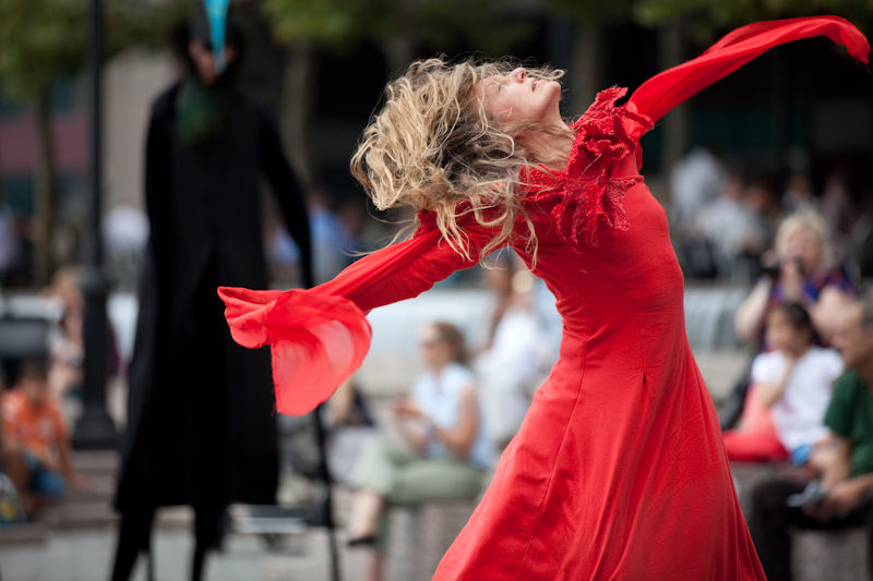 Felicia Norton lengthens her arms so that they make a long diagonal. Her head tilts back and her blonde long hair streams across her face.