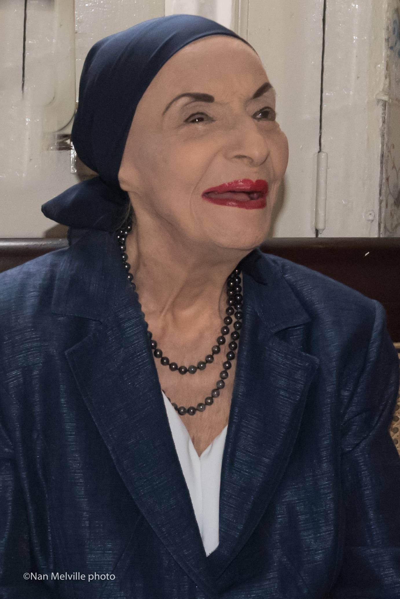 Alicia Alonso in a dark head scarf smiling