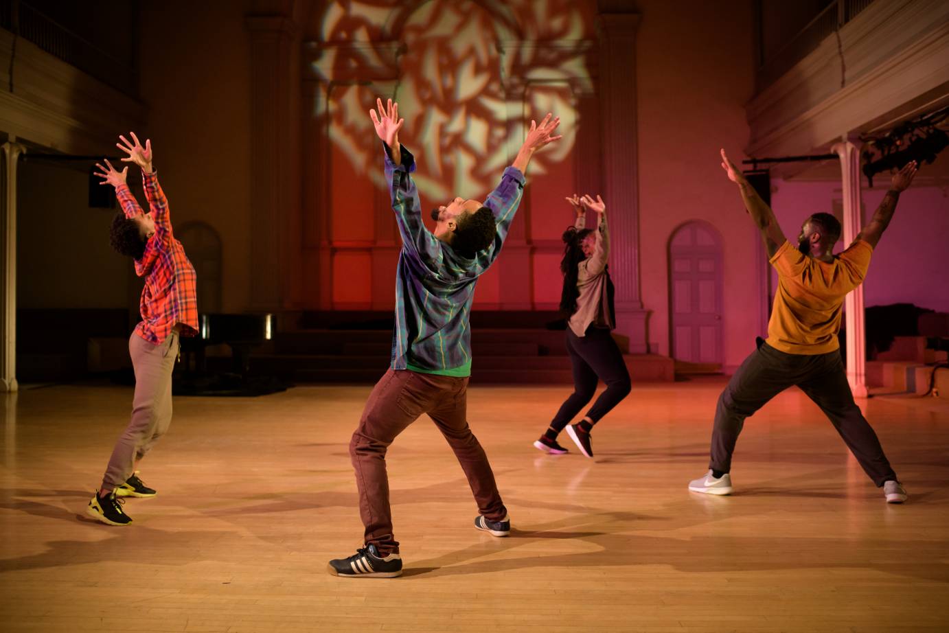 A group of dancers raise their arms ebulliently