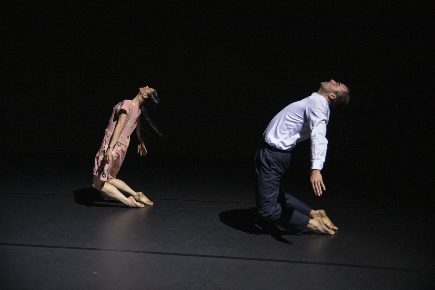 A man and a woman kneel with only their toes grazing the floor