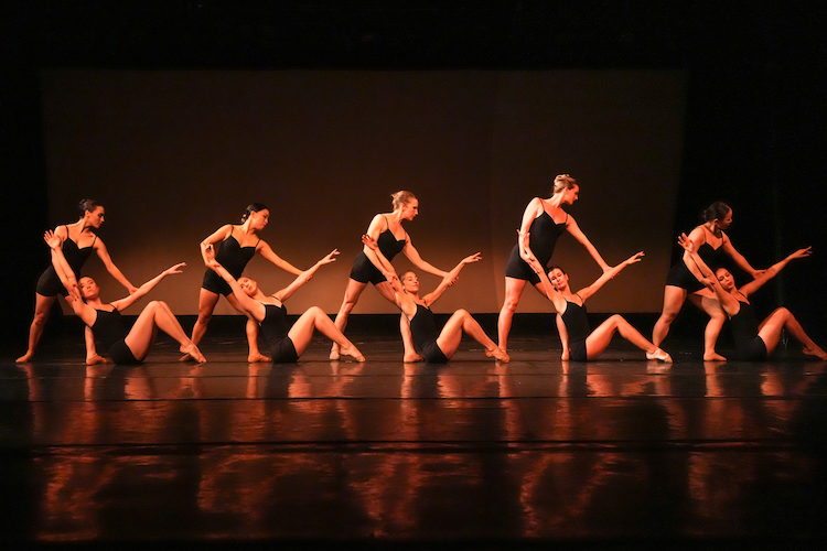 then female dancers in black camisole leotards with boy cut shorts strike a tableau resembling Egyptian hieroglyphics.