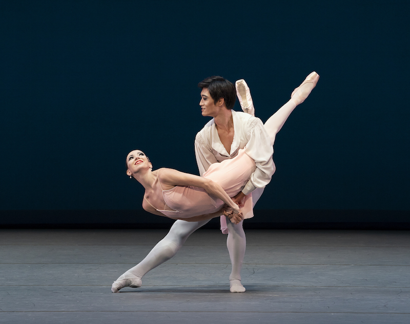 Kimin Kim in white holds Viktoria Tershkina in pink in a fish pose. 