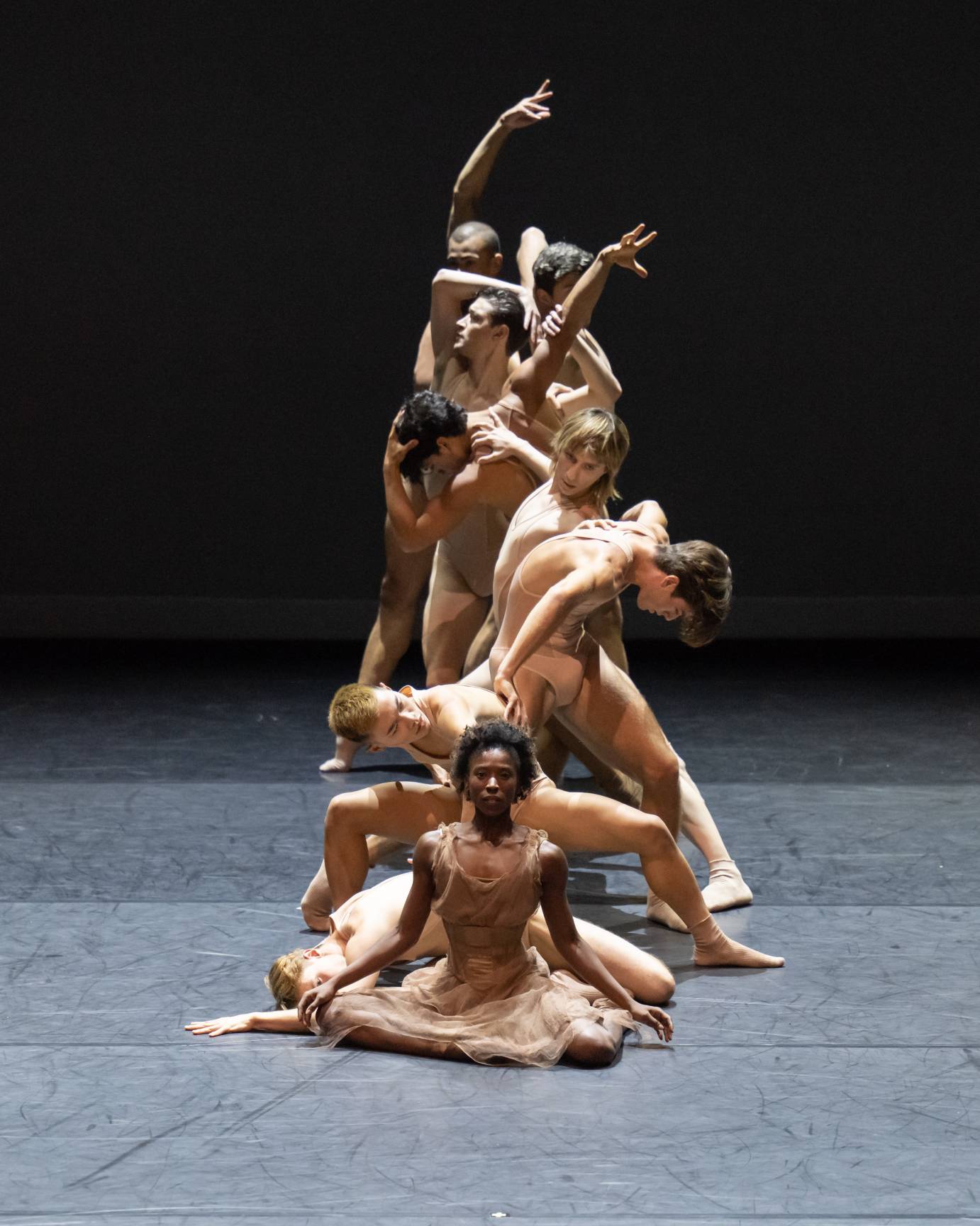 dancers arranged in a line front to back that increases in height  from front to back