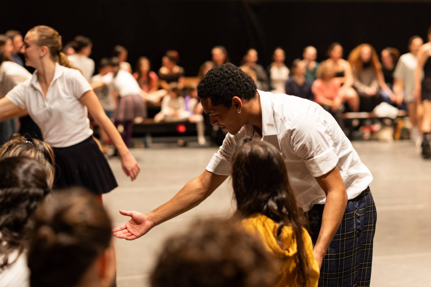 Dancer offering his hand to an audience member to join the dancers on stage