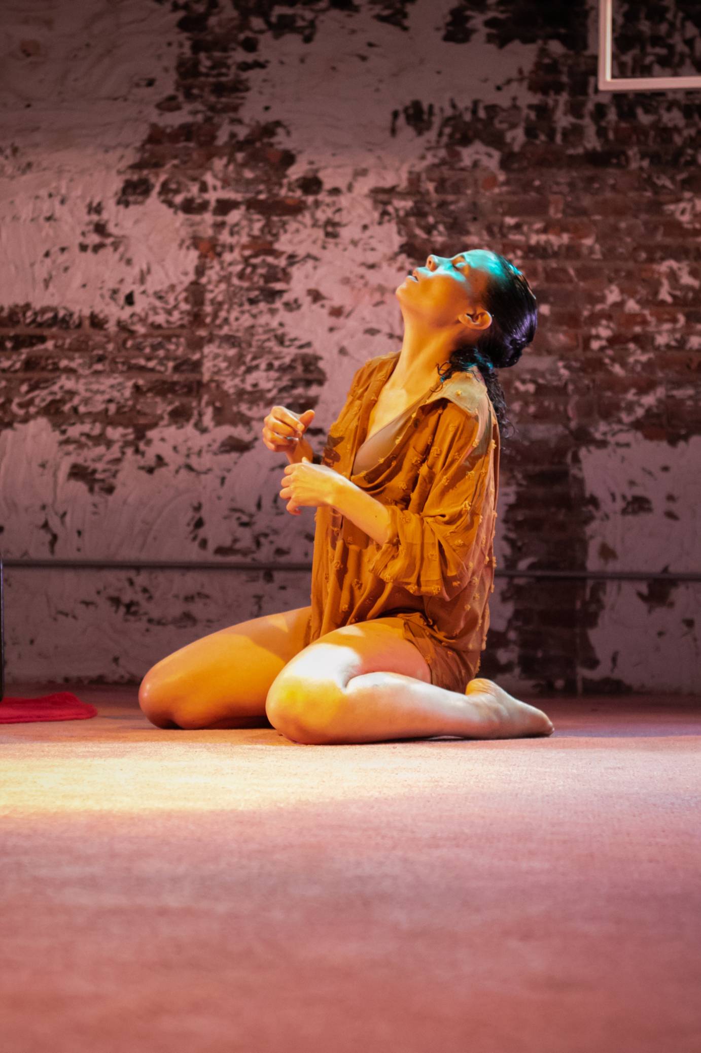 woman sitting on her knees arms loosely held in front of her chest