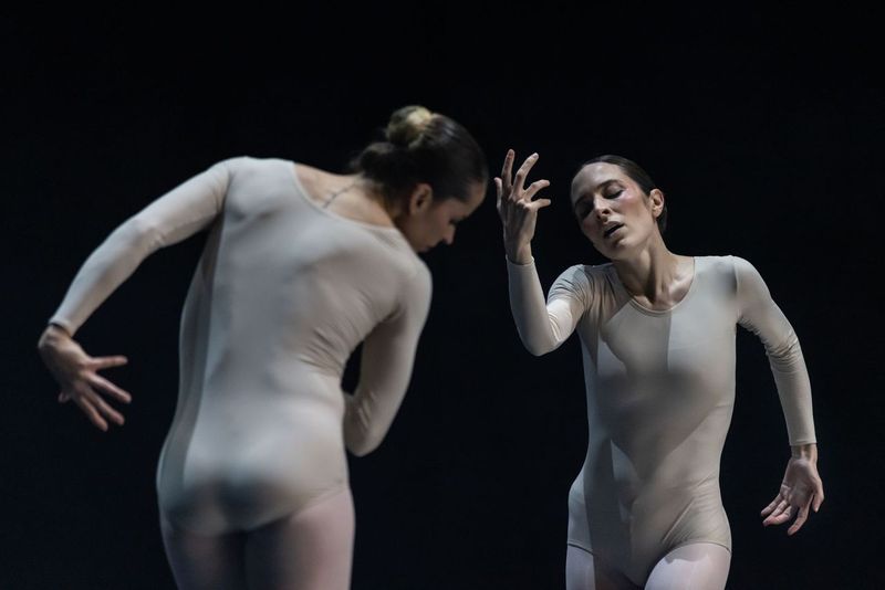 2 female dancers in white unitards in curved, asymetrical poses