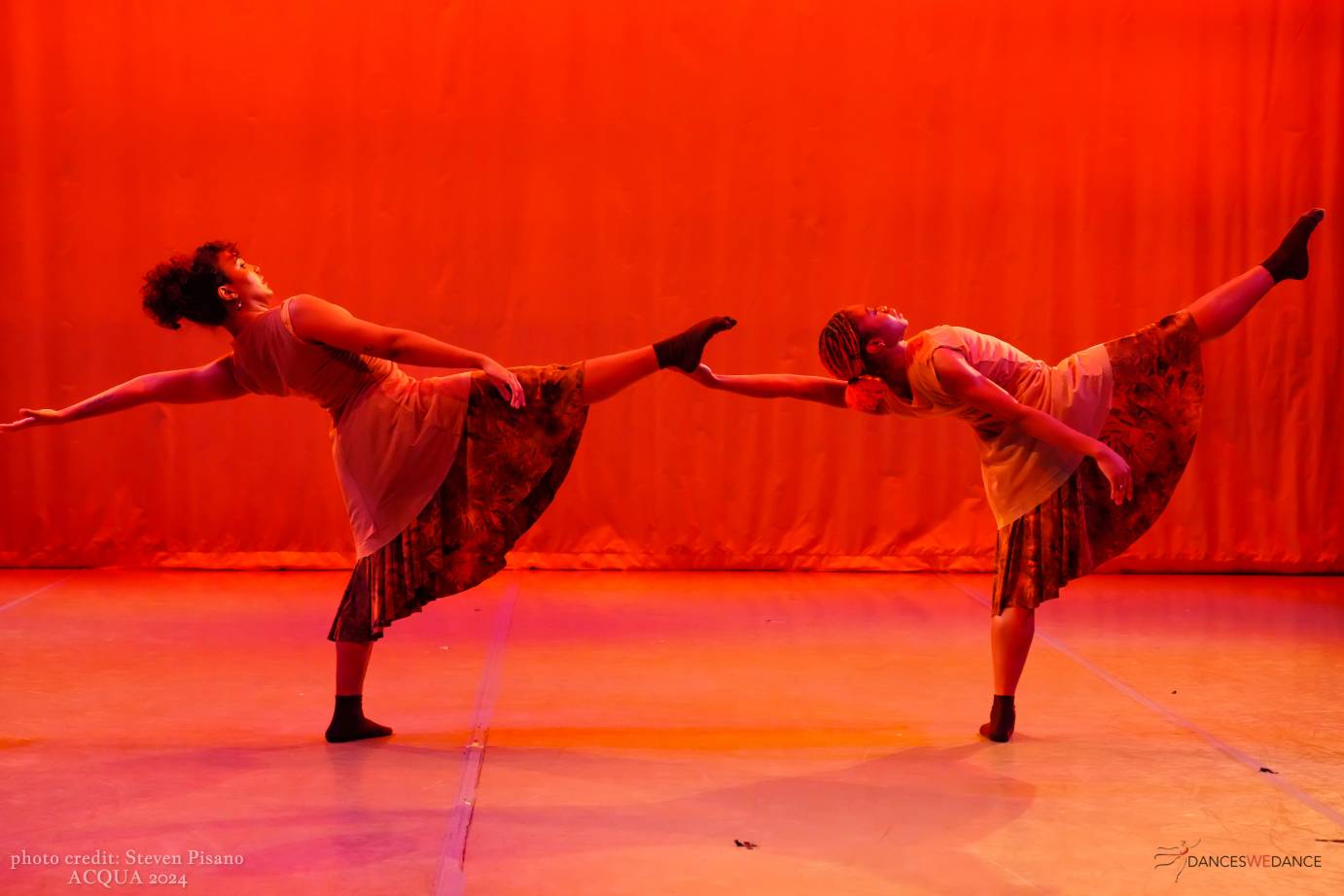 2 dancers in a layout with back arm extended back and right leg extended in front of them