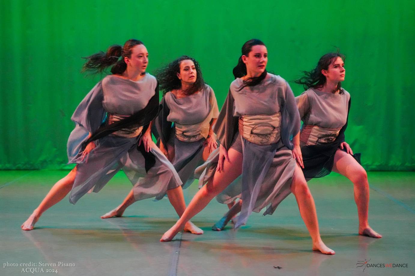 4 dancers in a tight clump, lunging to their left