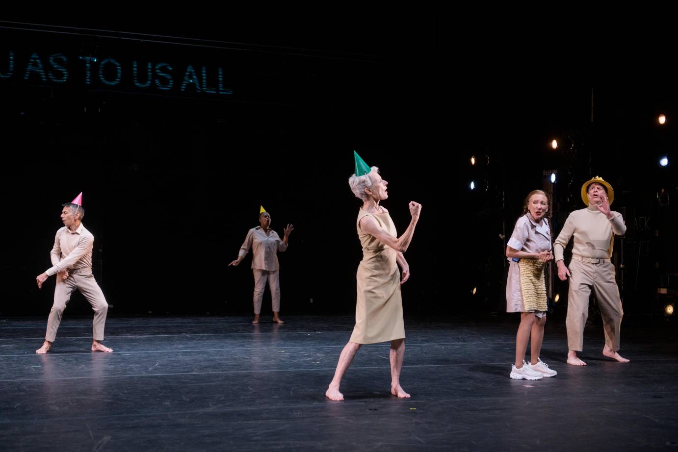 In party hats, dance elders move around the space