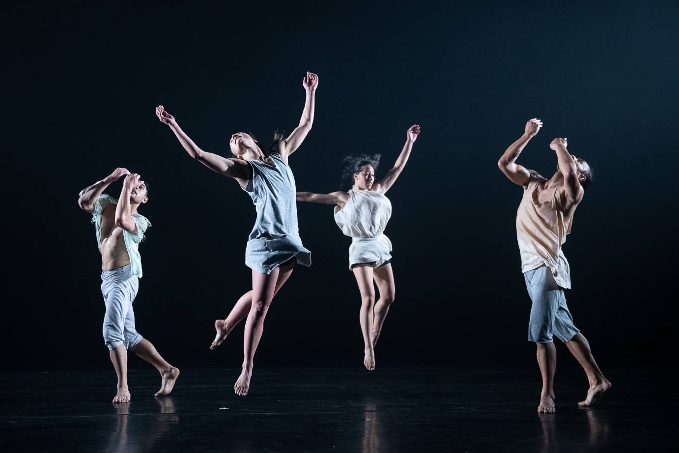 Dancers jump and gesture exuberantly