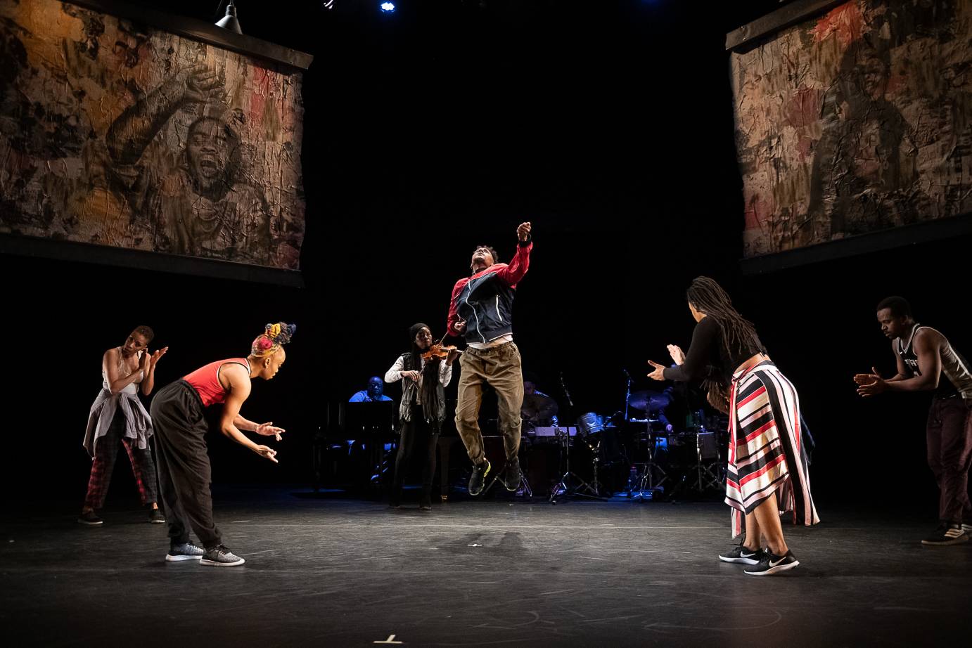 A man jumps in a middle of a circle of dancers