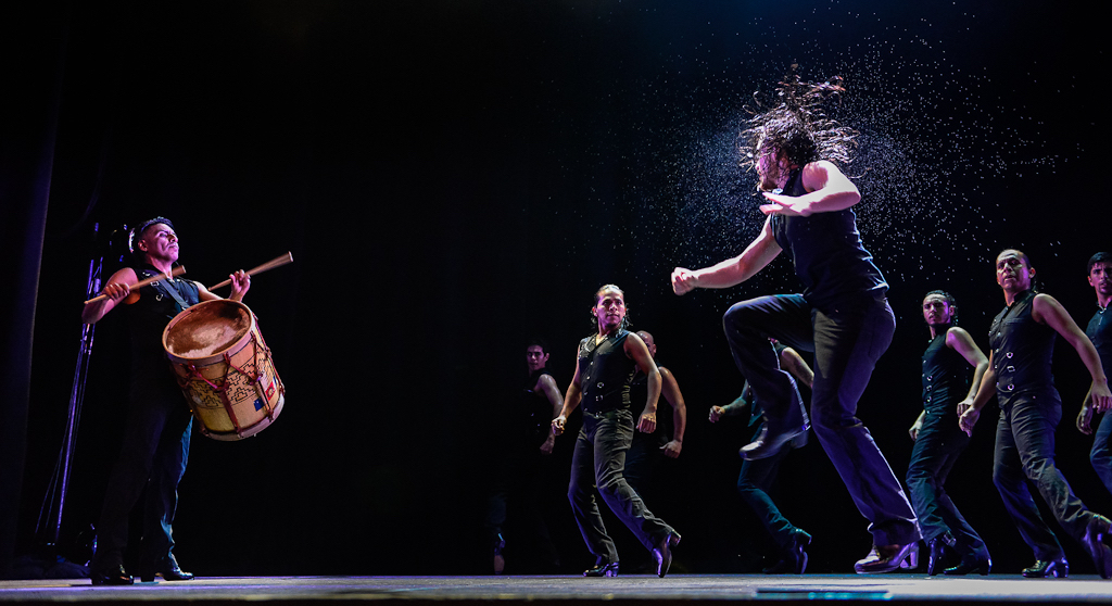 A man jumps, sweat pouring off his head.