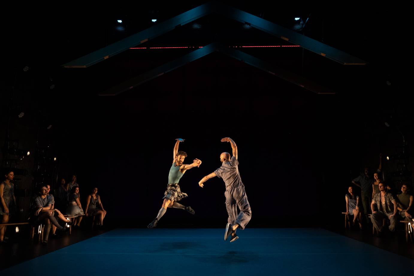 duet between two men one in an Irish kilt and the other in an American jumper the dancers mirror one another 