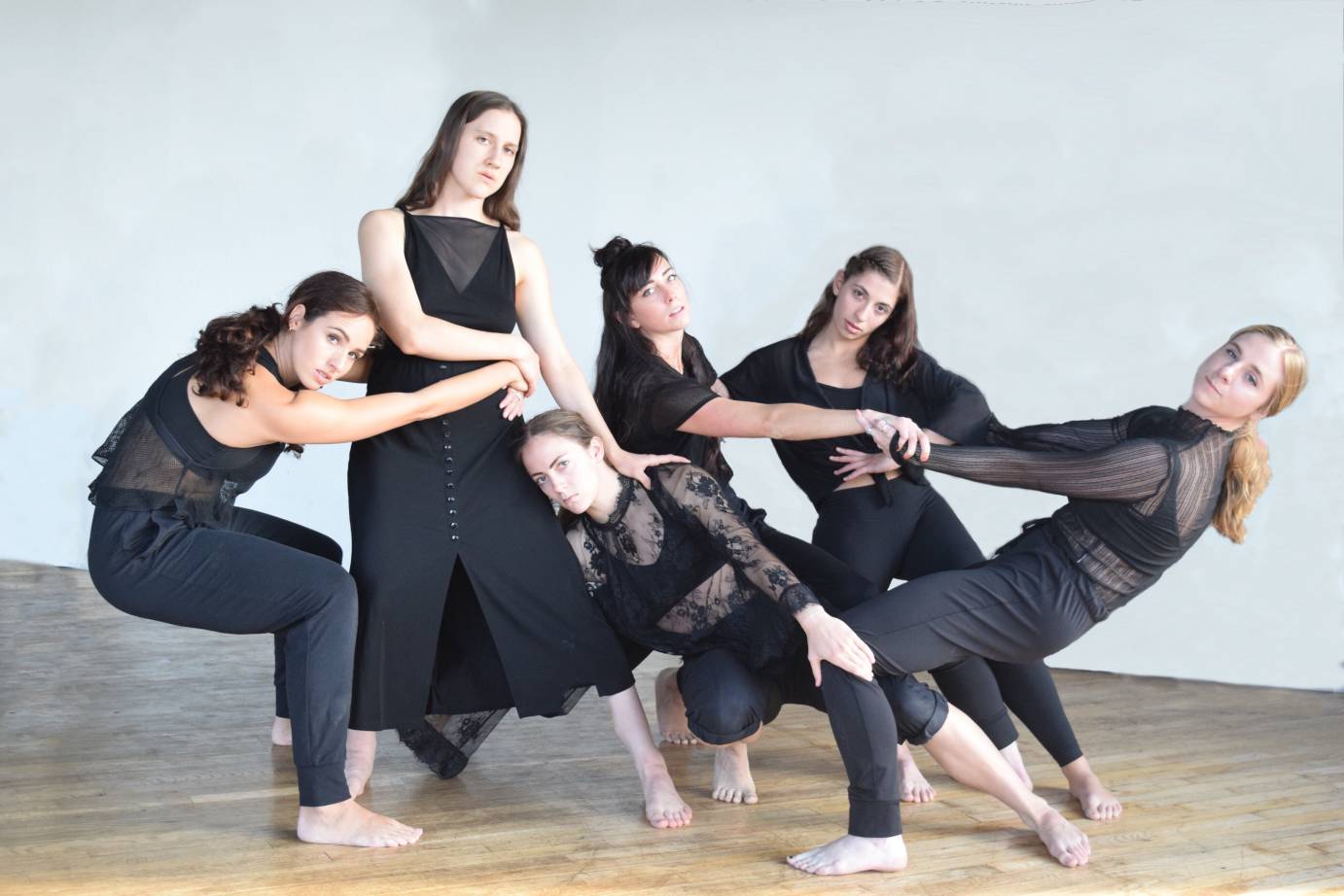 Dancers in black pull on each other