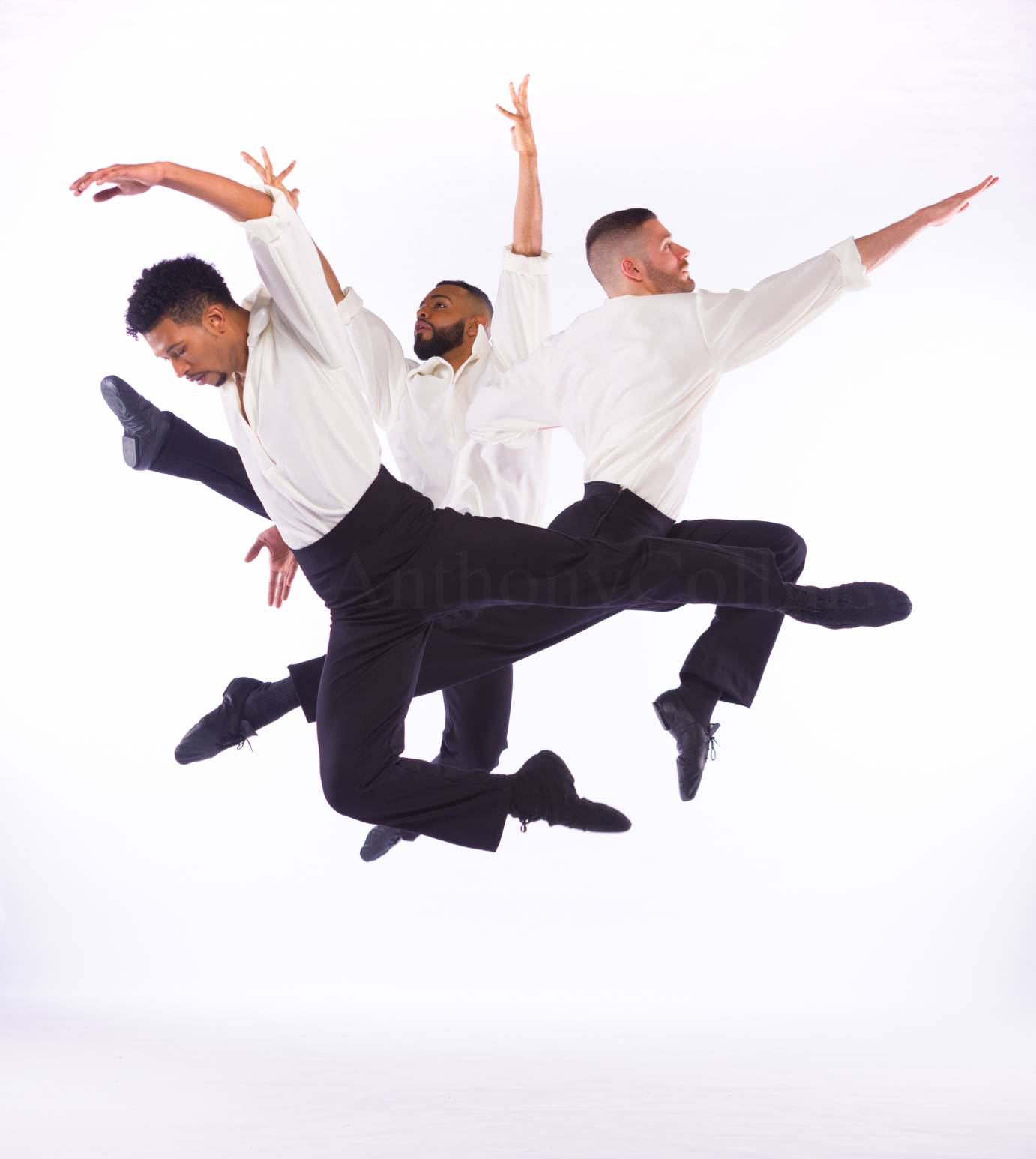 Three men jump exultantly with curved arms 