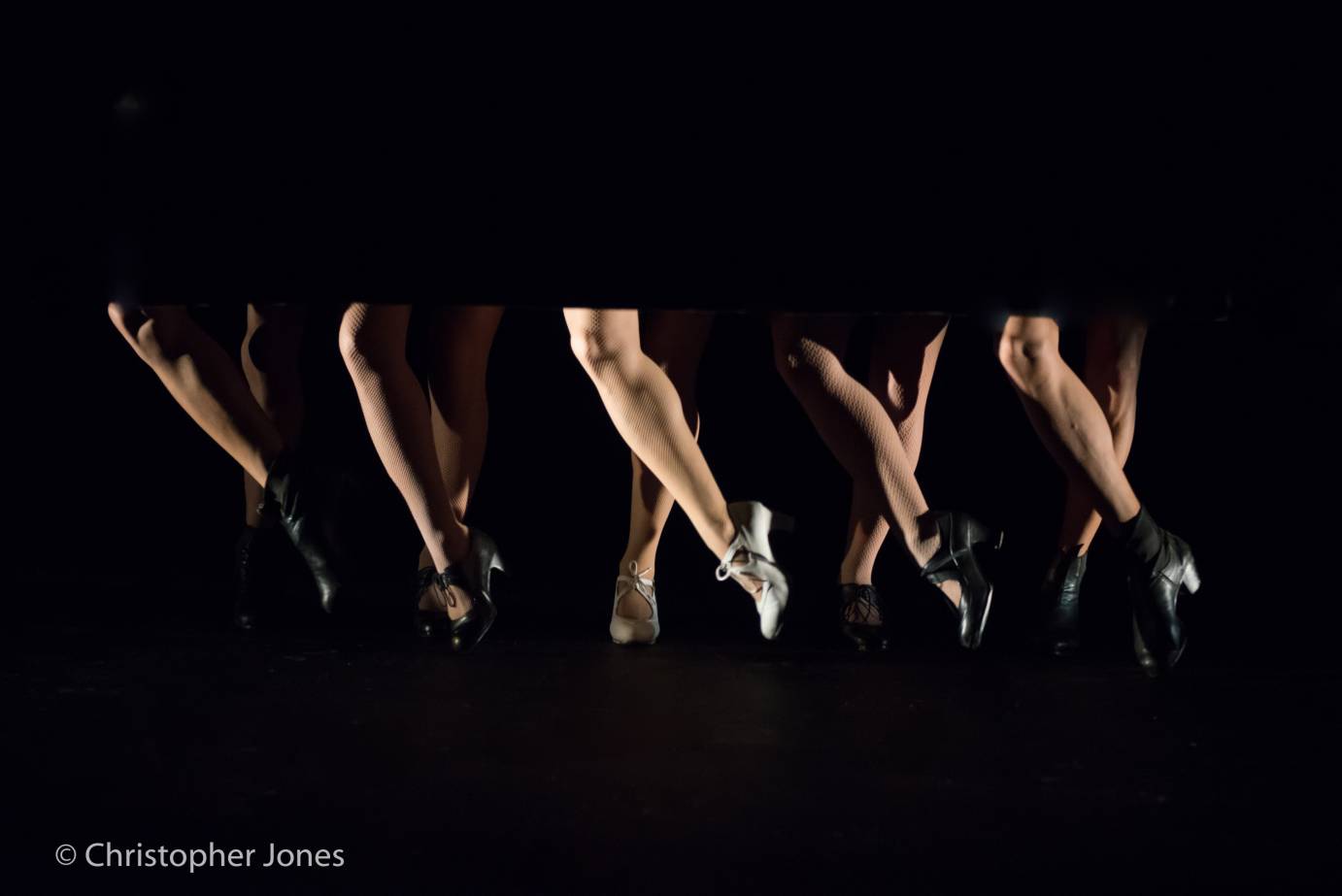 A curtain reveals only flamenco dancers' feet