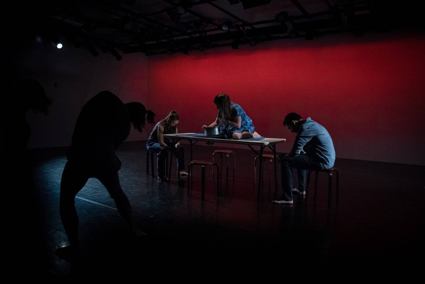 A trio gathers around a table, gesturing