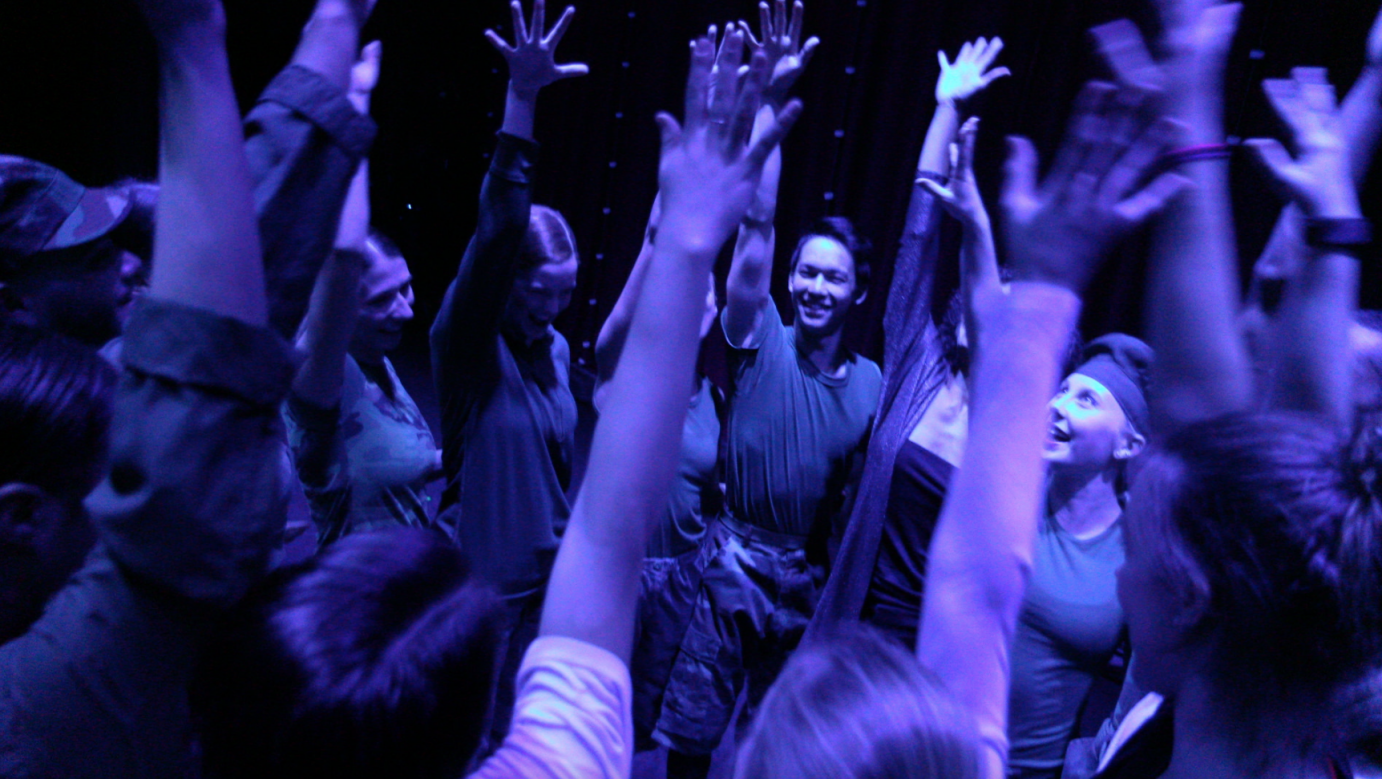 Loyola Marymount students raise their hands in the air