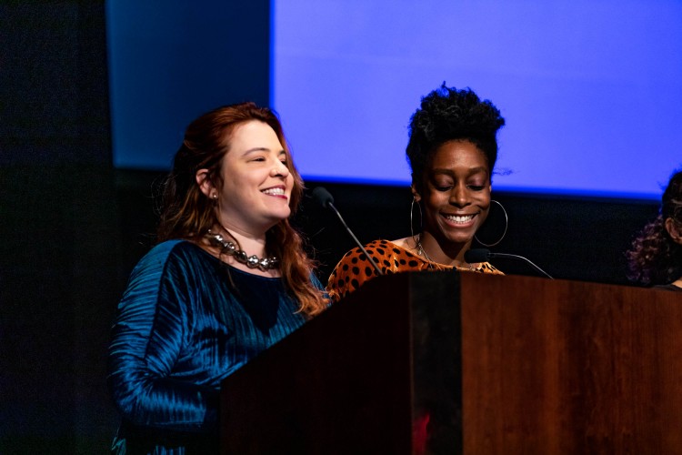 Two curators stand behind a lecturn