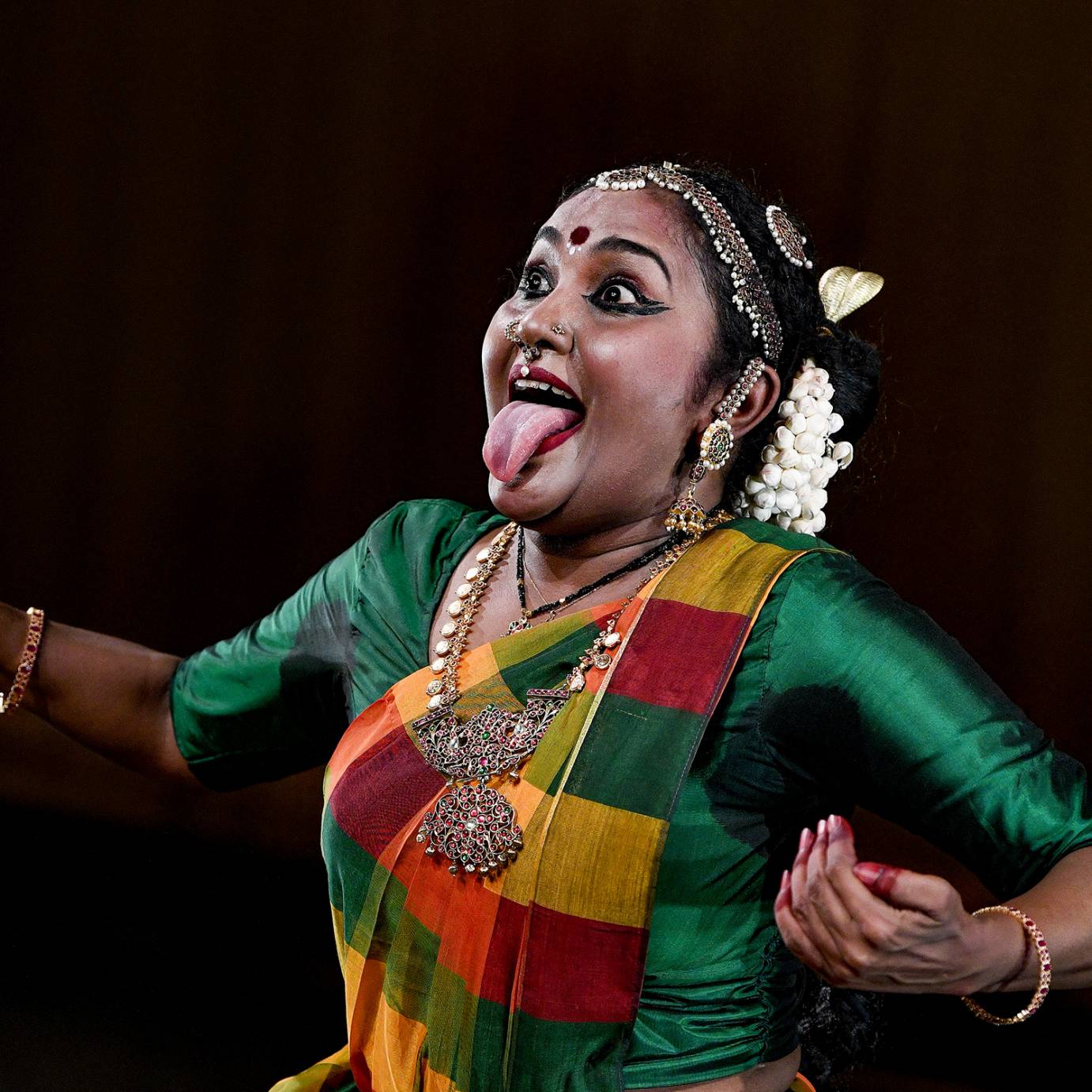 beautiful Indian woman bejeweled sticking out her tongue like a huge frog