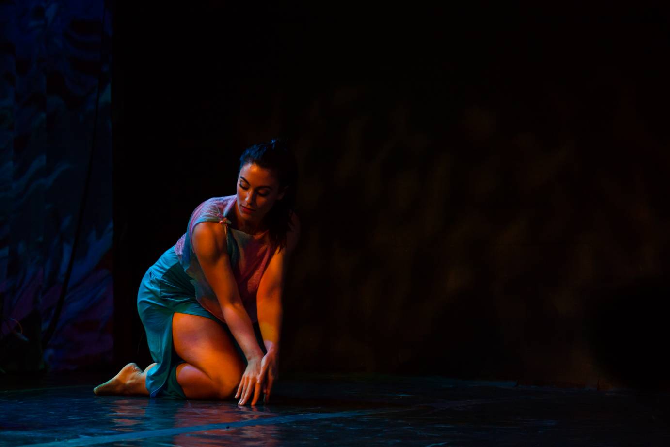 Irish dancer on knees crouched over eyes closed representing an undersea creature