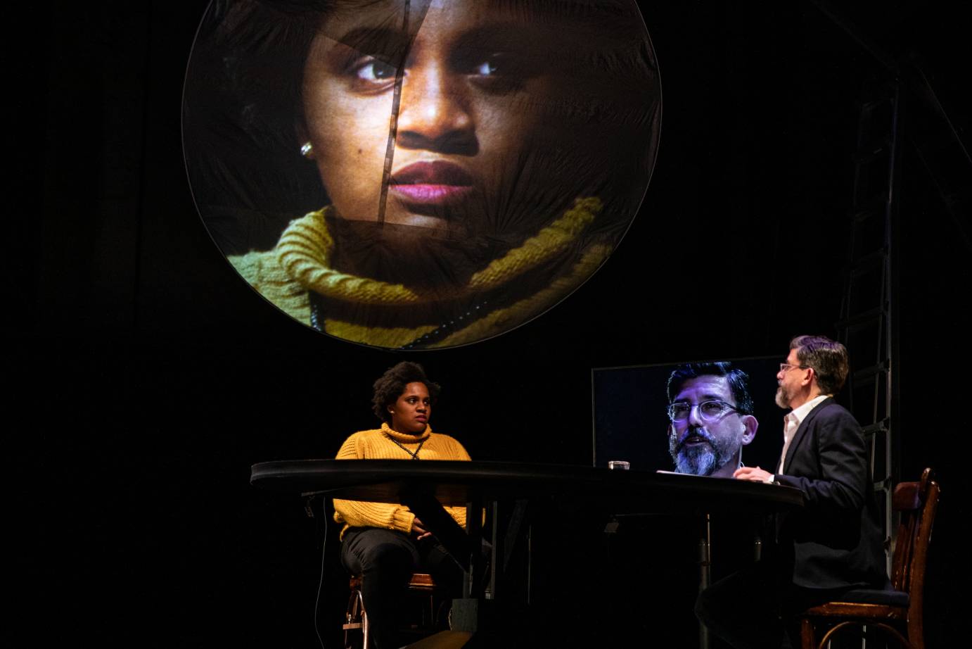 Marcella Murray and David Neumann sit at a table with their images projected