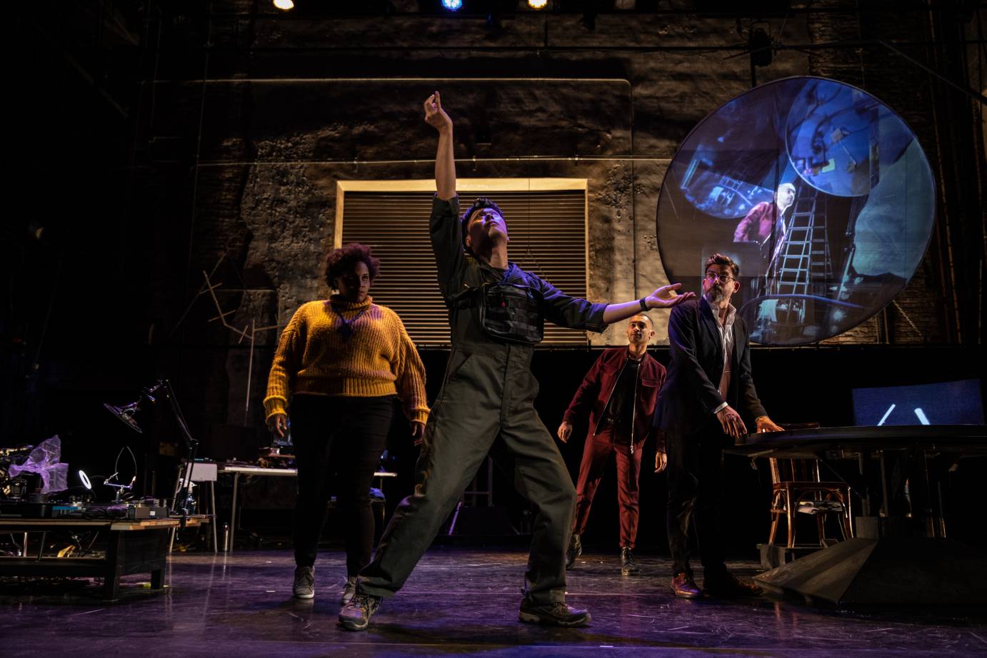 The cast stands, with one man downstage extending his arms up