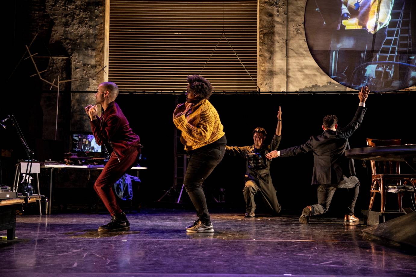 Two dancers boogie while two others kneel, facing opposite directions