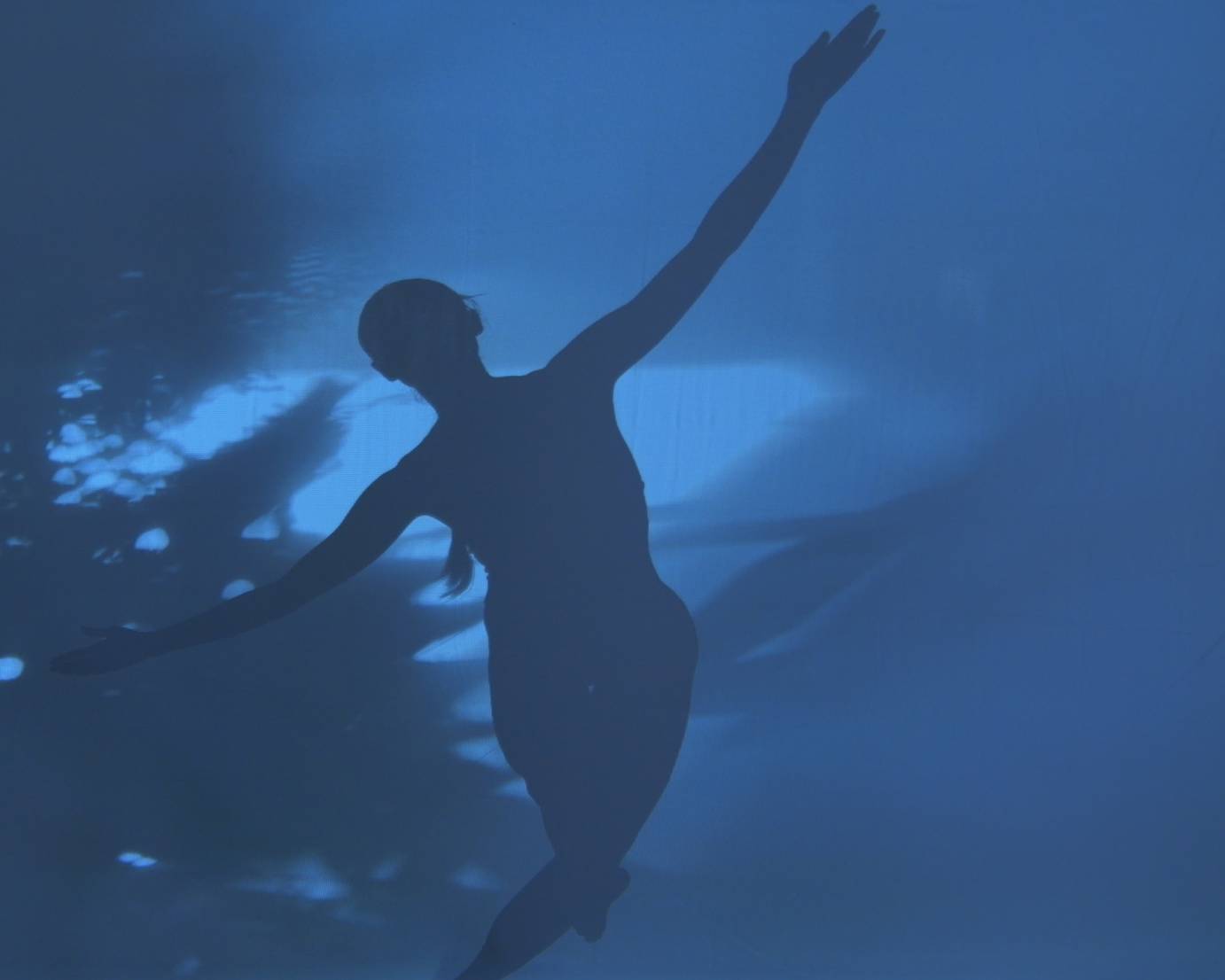 Woman seen in silhouette against a blue background