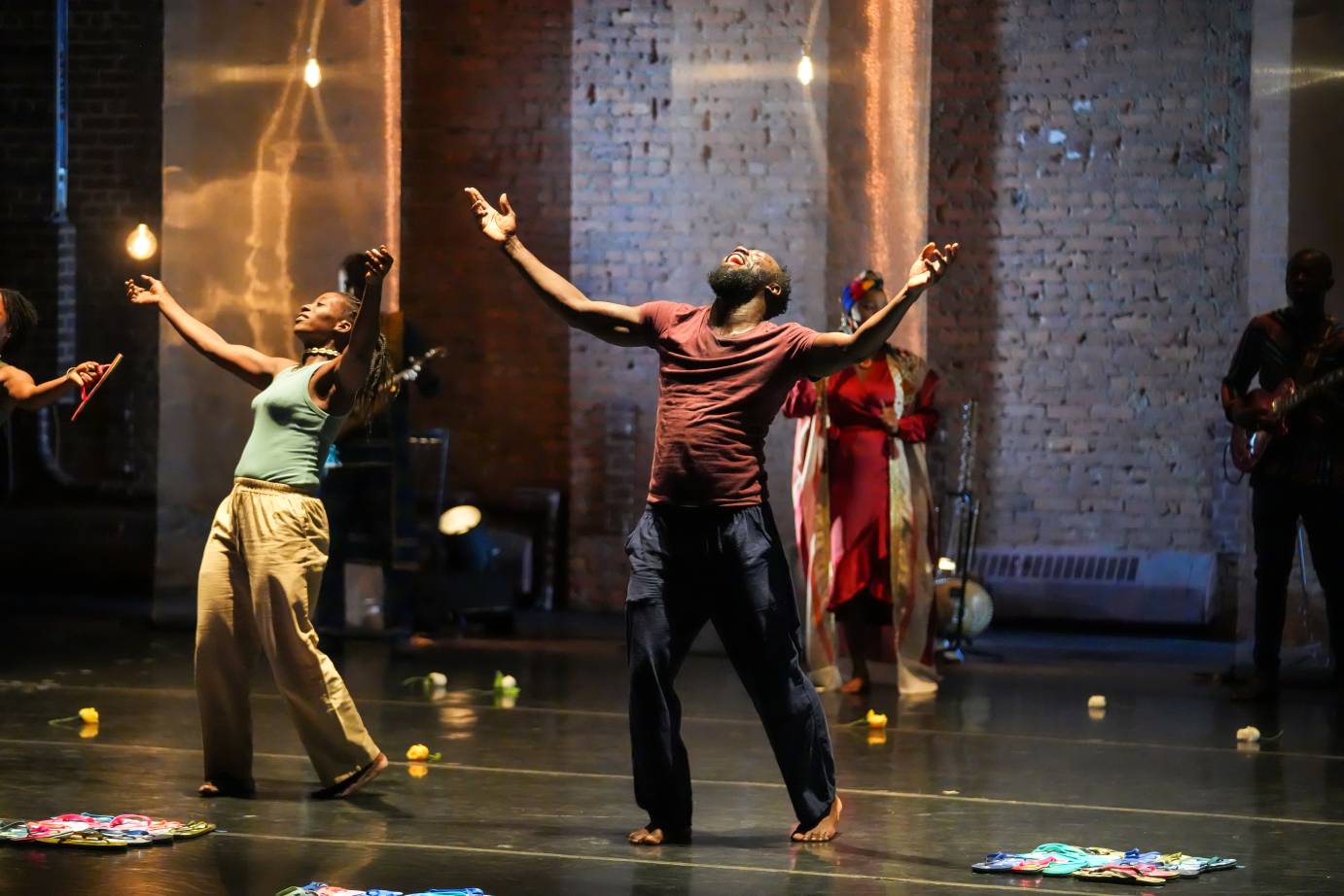 2 dancers arms outstretched, faces toward the sky