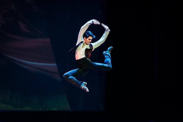 a Spanis Dancer performs a stag leap in the air... he's caught in the photo at the leaps highest moment 