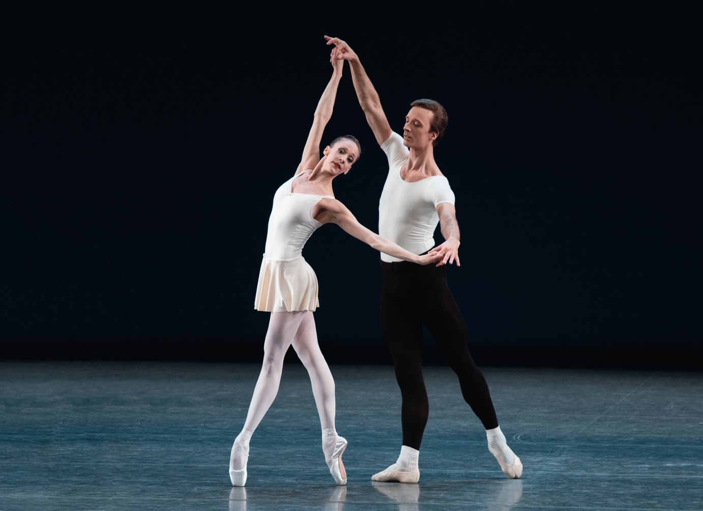 Ask la Cour partners Maria Kowroski. Wearing ballet class outfits, he stands with one leg behind him in tendu and she is in fourth position en pointe.