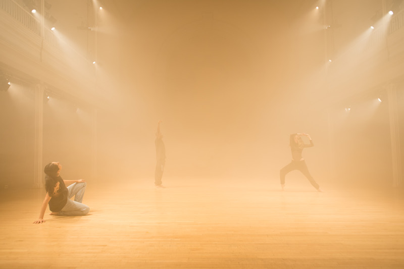 A man points his finger younger a yellow stage light in the balcony