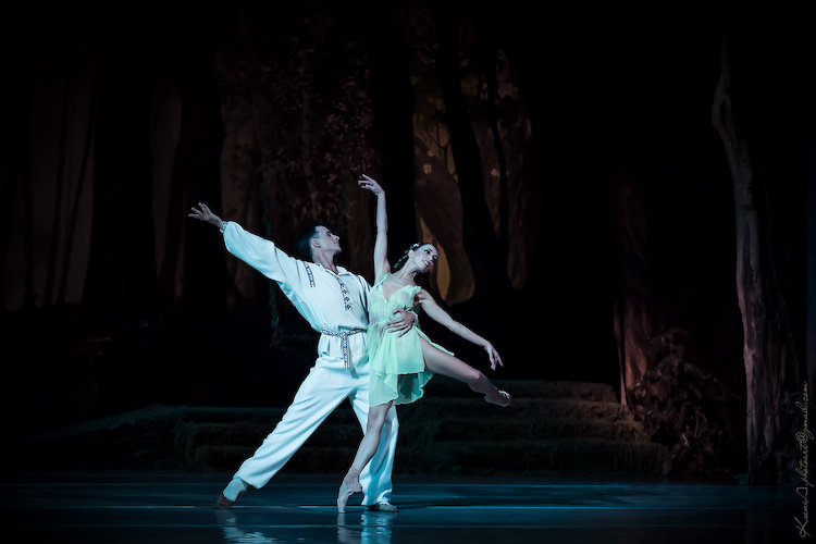 pas de deux... man in white ukrainian outfit, woman in chiffon green being held to his waist, she looks like a forest nymph