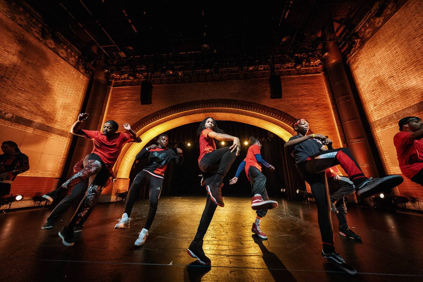 A group of young men and women lift a knee high in the air