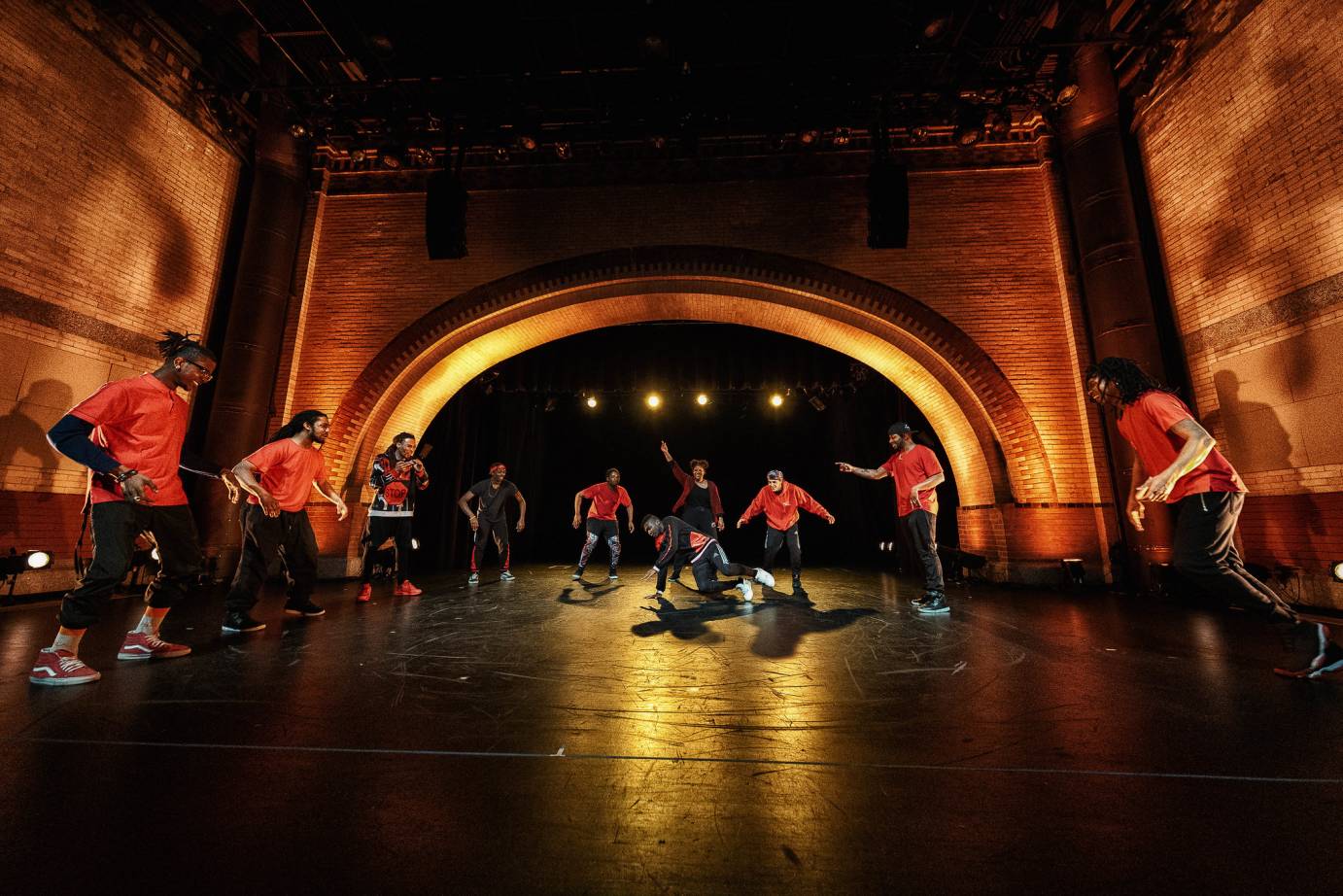 A group forms a semicircle around a break dancer